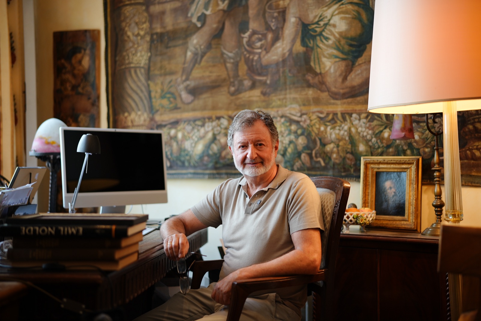 Isai Liven an seinem Schreibtisch unter der Tapisserie